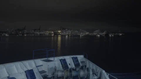 Cargo ship navigating Vuosaari port at night with illuminated waterfront view Stock Footage 338264918