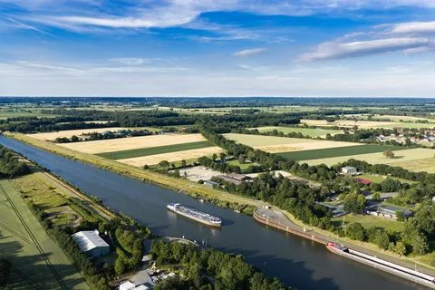 Cargo ship passing through canal in Germany. Transport logistics. Canal aerial Stock Photos