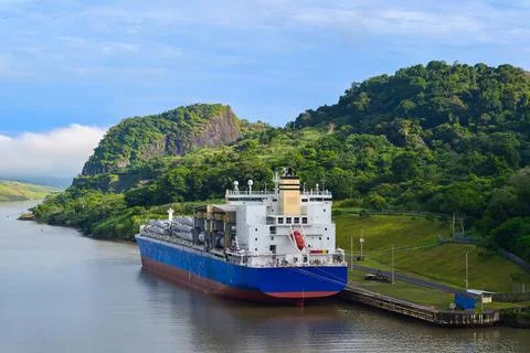 Cargo ship passing through the panama canal on a sunny day Stock Photos