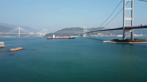 Cargo ship passing under a bridge in Hong Kong 库存影片 229825479