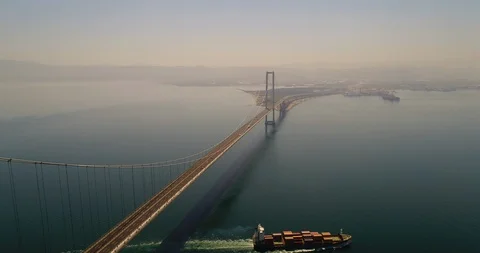 Cargo Ship Passing Under Suspension Bridge. 4K Aerial Footage Stock Footage 94762877
