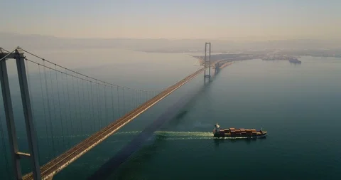 Cargo Ship Passing Under Suspension Bridge. 4K Aerial Footage Stock Footage 94762934