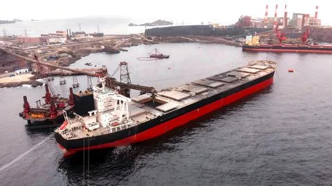 Cargo ship in the process of loading minerals from a mine for export Stock Photos