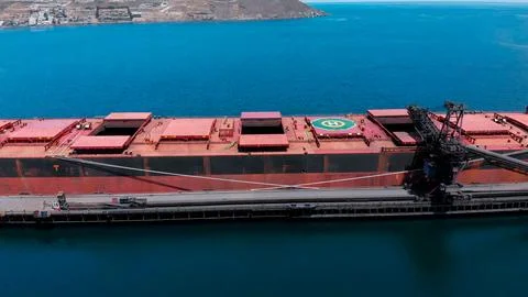Cargo ship in the process of loading minerals from a mine for export Stock Photos
