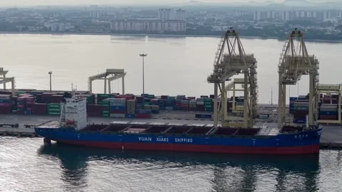 Cargo ship rests beside massive cranes Stock Footage 346792424
