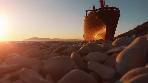 Cargo ship run aground after shipwreck on rocky shore waiting for help Stock Footage 107859238