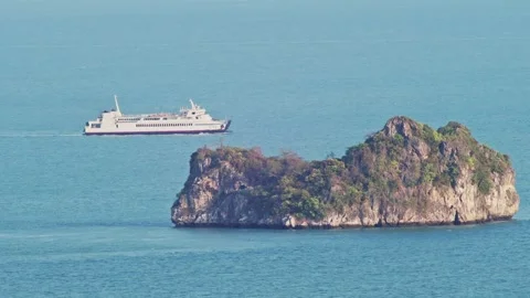 Cargo Ship Sailing Behind Island on Calm Morning Sea 動画素材 333547359