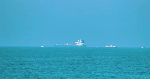 Cargo ship sailing on calm turquoise ocean waters 스톡 동영상 339519720
