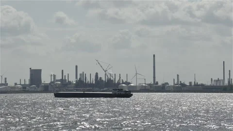 Cargo Ship Sailing in Foreground of Large Industrial Area Stock Footage 277361599