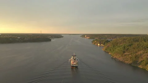 Cargo ship sailing the inlet archipelago, aerial view flying behind the vessel Stock Footage 136094177