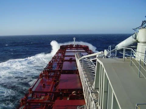 Cargo ship sailing in the ocean Stock Photos