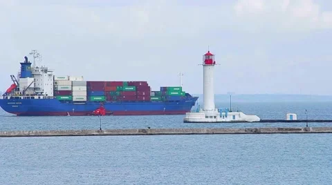 Cargo ship sailing  past the lighthouse to open sea Stock Footage 57882462