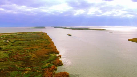 Cargo ship sailing through a large river delta aerial view Stock Footage 337011832
