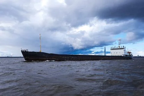 Cargo Ship Sailing Through Rough Sea Under Clouds Stock Photos
