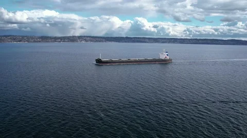 Cargo ship sailing through water zoom in long distance Stock Footage 209348819