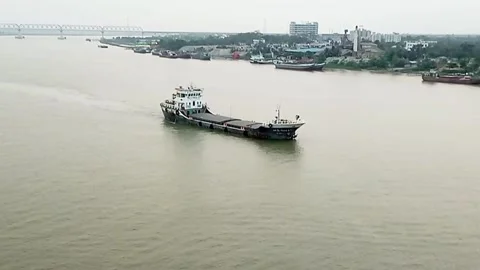 Cargo ship sailing on a wide river near the city Stock Footage 318694201