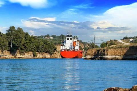 Cargo ship sails between the rocks of the Corinth Canal, Peloponnese, Greece Stock Photos