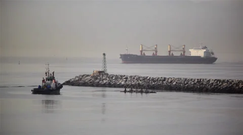 Cargo Ship Sails Into Port Beyond Rocks Video stock 38296668