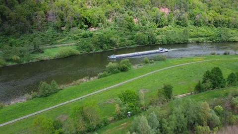 A cargo ship sails quietly along the river through the field and forest Stock Footage 154376593