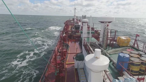 Cargo ship sails in stormy ocean and waves crash on board Stock Footage 148388754