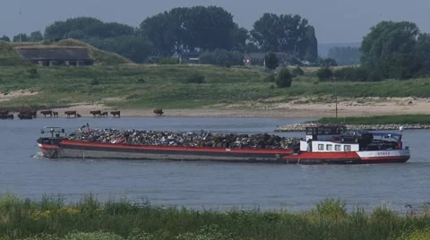 Cargo ship with scrap downstream the River Waal, Fort Pannerden in background, Stock Footage 52118892