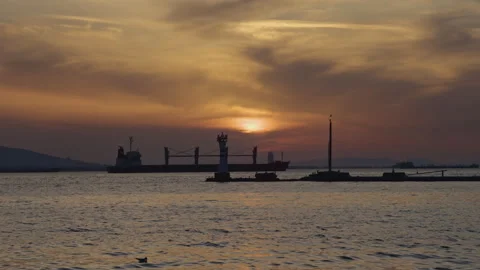 Cargo Ship Silhouette at Sunset on Calm Sea Stock Footage 330272739