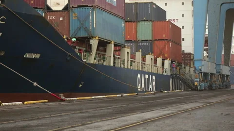 Cargo ship unloading containers at the port on a cloudy day Stock Footage 318195847