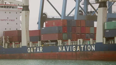 Cargo ship unloading containers at port in Qatar during daylight Stock Footage 318200495