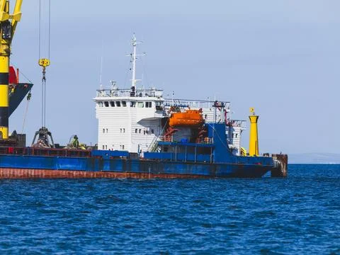 Cargo ship unloading freight at a commercial port Stock Photos