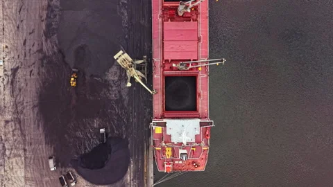 Cargo ship unloads material at large port area during daylight hours with 스톡 동영상 340883194
