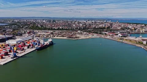 Cargo ships and containers at a busy port in a coastal city Stock Footage 339018754