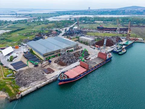 Cargo ships dock at a port for loading and unloading materials near a large.. Fotos de archivo