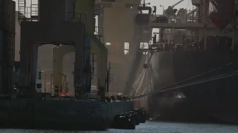 Cargo ships dock at port for unloading goods during early morning hours with Stock Footage 334626999