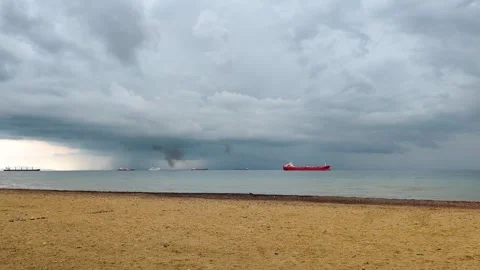 Cargo Ships on Horizon under Dramatic Stormy Sky and Empty Beach Stock Footage 334820528