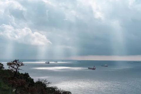Cargo ships queuing in a bay under dramatic sky. 스톡 사진