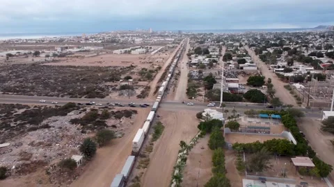 Cargo Train Crossing Desertic Landscape with Ocean View || DRONE VIEW Stock Footage 235877292