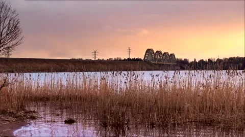 Cargo train crossing the river on a sunset. Video stock 155403434