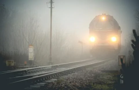 Cargo train emerging from the mist Stock Photos