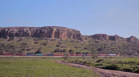 Cargo train passing through a beautiful countryside cliffs landscape Stock Footage 46011720