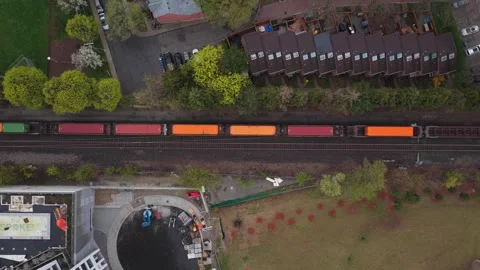 Cargo train with shipping containers travelling along urban railway tracks near Stock Footage 334697050