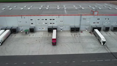 Cargo truck with a trailer is parked in reverse near a huge logistics center to Stock Footage 188745692