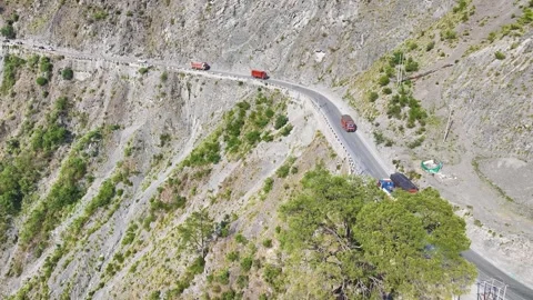 Cargo trucks navigating a dangerous mountain cliff road Video stock 337618935