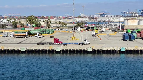 Cargo trucks transporting shipping containers at various stages of transit in Vídeos de archivo 331157483