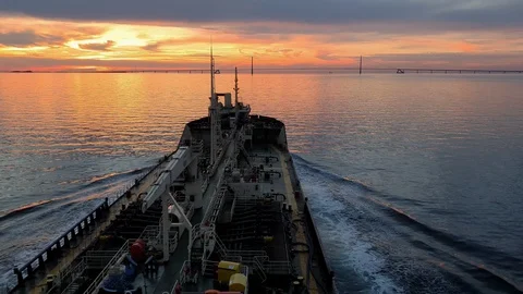Cargo vessel with antennas on bow sails on river at sunset Stock Footage 113188668