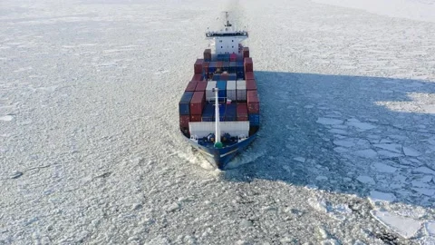 Cargo vessel goes through the ice floes on water, drone view Stock Footage 170384941