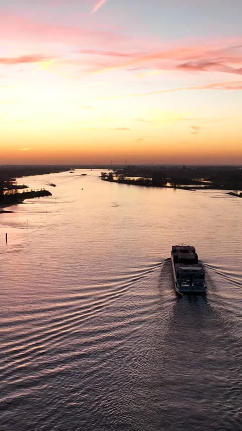 Cargo vessel on a river during sunset in Europe Stock Footage 334941513