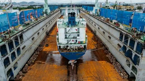 Cargo Vessel Undergoing Maintenance Inside A Dry Dock Facility High Angle Sho 스톡 사진