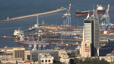 Cargo vessels and modern office tower at Haifa seaport, largest harbor Israel Stock Footage