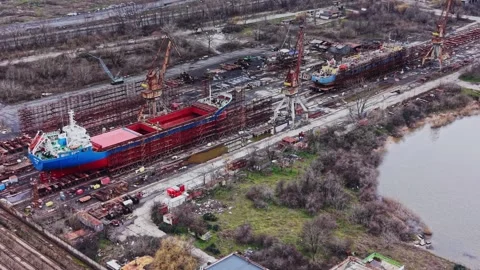 Cargo vessels being repaired at a busy shipyard during daytime Vídeo Stock 337941047