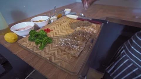 Caribbean chef spicing up cod fish before searing Stock Footage 267007855